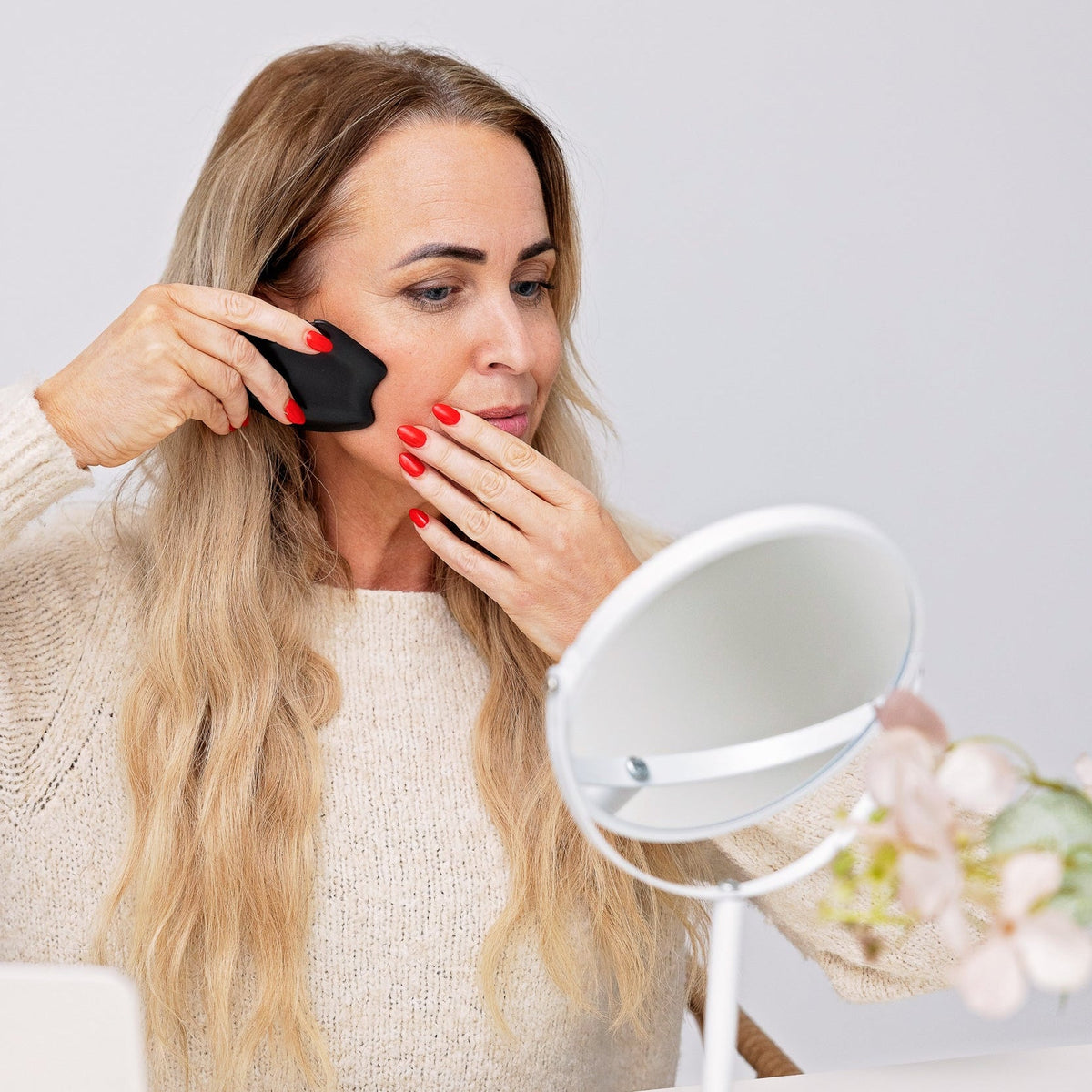 Susanne Dyhr bruger en sort gua sha-sten i bian-sten til ansigtsmassage